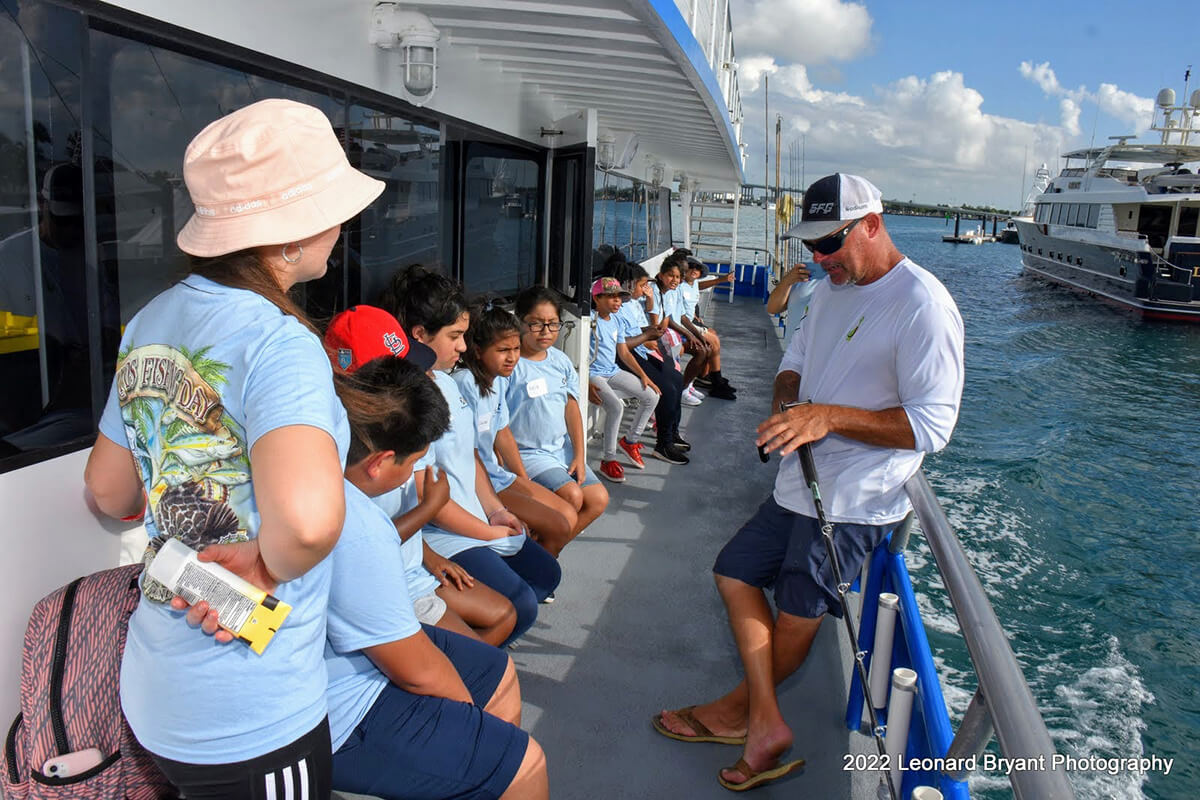fishing crew talking to kids about how to fish on offshore fishing boat